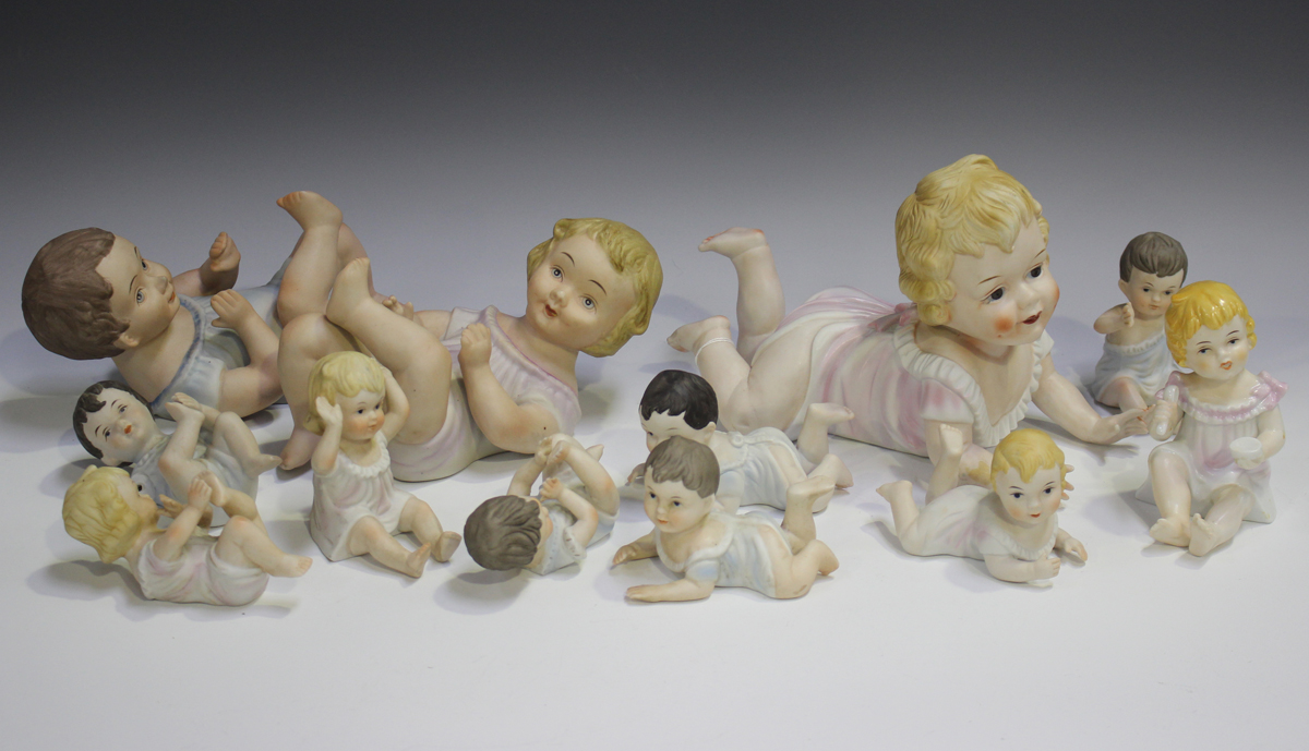 Eleven bisque porcelain piano babies, early 20th century and later, together with a similar