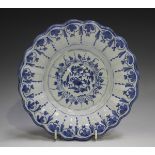 A Delft moulded dish, 18th century, painted in blue with flowers, the fluted rim with a continuous