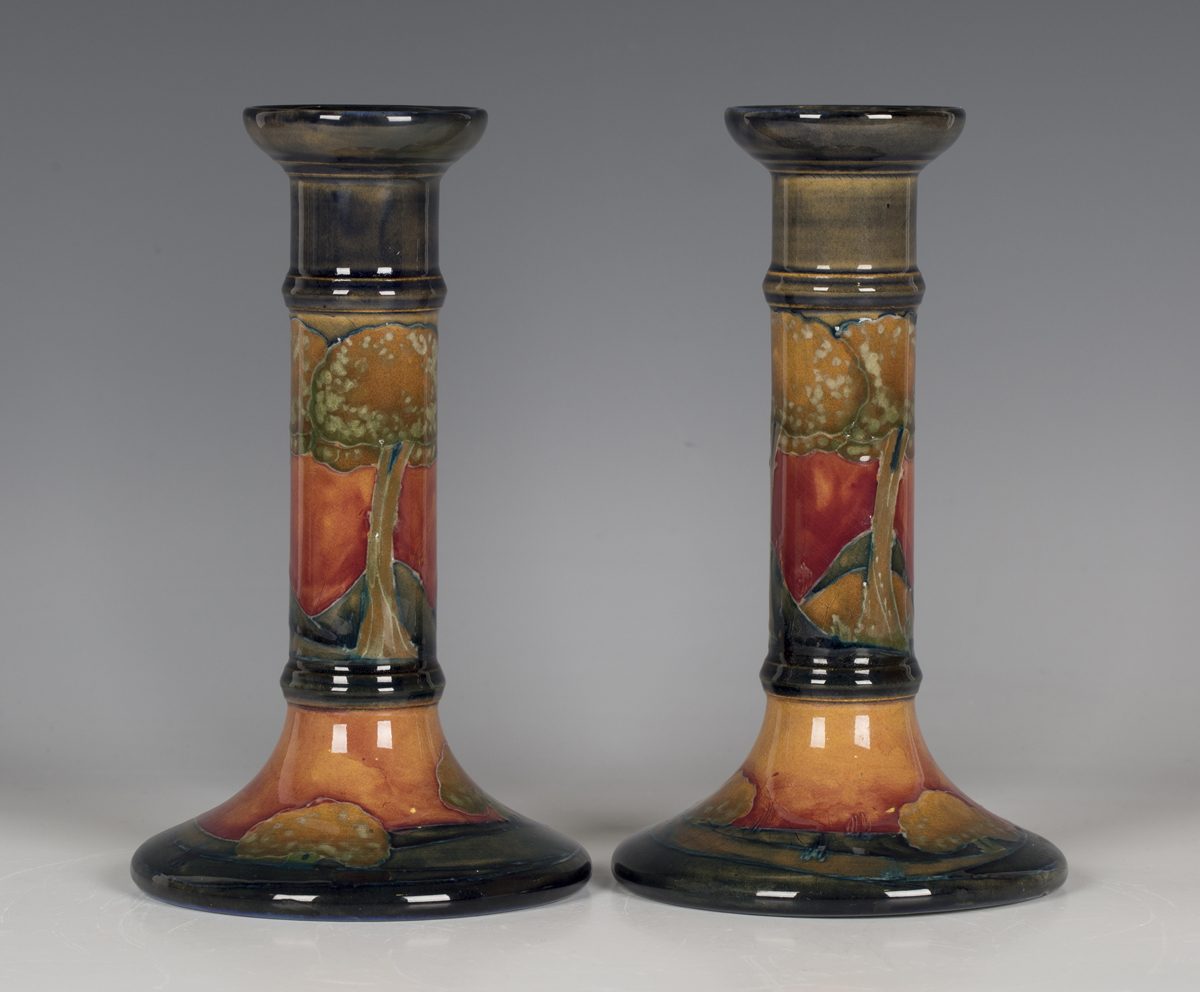 A pair of Moorcroft Eventide pattern candlesticks, circa 1925, each of cylindrical form, impressed