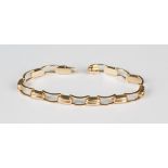 A gold bracelet in a curved and twin bar link design, on a snap clasp, marked '14K', with a foldover