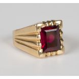 A gold ring, circa 1950, mounted with a rectangular step cut synthetic ruby between ridged