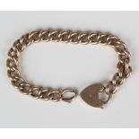 A gold hollow curblink bracelet on a gold heart shaped padlock clasp, detailed '9ct', weight 18.