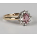 A 9ct gold, pink tourmaline and diamond oval cluster ring, claw set with the oval cut pink