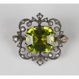 A late Victorian gold backed and silver set peridot and diamond brooch, claw set with the