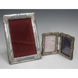 An Edwardian silver rectangular photograph frame, each corner embossed with flowers and leaves,