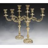 A pair of Edwardian silver twin-branch three-light candelabra, each foliate scroll branch with urn