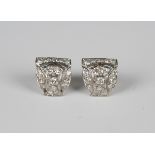 A pair of diamond earstuds, each in a curved panel shaped design, mounted with circular cut