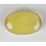 An early 19th century gold mounted oval dyed pale green agate brooch, unmarked, width 4.5cm.Buyer’