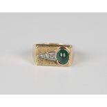 A diamond and cabochon emerald ring, mounted with an oval cabochon emerald and a row of three