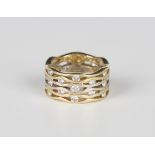 A two colour gold and diamond wide band ring in a pierced abstract design, mounted with circular cut