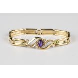 A gold, amethyst, peridot and seed pearl bracelet, the front in a foliate scroll design, set with