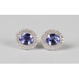 A pair of 18ct white gold, tanzanite and diamond cluster earstuds, each claw set with the
