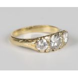 A gold and diamond three stone ring, mounted with a row of circular cut diamonds and two pairs of
