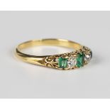 A gold, emerald and diamond five stone ring, mounted with three emeralds alternating with two