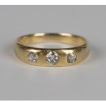 A gold and diamond three stone ring, gypsy set with a row of cushion cut diamonds, weight 4g, ring