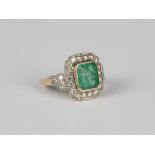 A gold, emerald and diamond cluster ring, mounted with the cut cornered rectangular step cut emerald