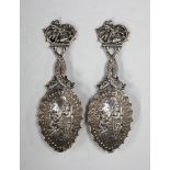 A pair of early 20th century Continental .800 silver caddy spoons, each bowl cast in relief with two
