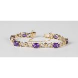 A 9ct gold and amethyst bracelet, claw set with a row of seven oval cut amethysts, on a snap