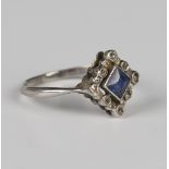 A diamond and sapphire square shaped cluster ring, mounted with the square cut sapphire within a