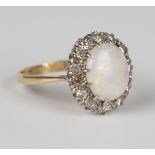 A gold, opal and diamond oval cluster ring, claw set with the oval opal within a surround of