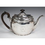 An Edwardian silver oval teapot with hinged lid and ebonized scroll handle, engraved with