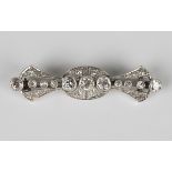 A diamond brooch in an oval and tapered design, mounted with cushion cut diamonds, the three
