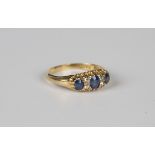 An 18ct gold, sapphire and diamond ring, mounted with three oval cut sapphires alternating with