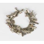 A silver curblink charm bracelet, fitted with a variety of mostly silver charms, including a