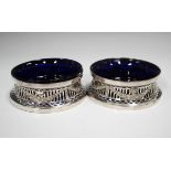 A pair of George V silver diminutive dish rings, each pierced and embossed with festoons, Chester