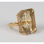 A gold ring, claw set with a cut cornered rectangular step cut citrine, unmarked, weight 12.2g, ring
