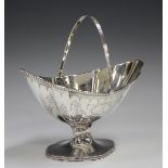 A George III silver basket of boat shaped form with reeded swing handle and beaded rim, engraved