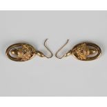 A pair of Victorian gold pendant earrings, each with a foliate capped acorn to the centre within