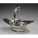 A George III silver basket with reeded swing handle and shaped rim, engraved with a foliate band, on