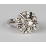 A white gold and diamond cluster ring, claw set with the principal circular cut diamond within a