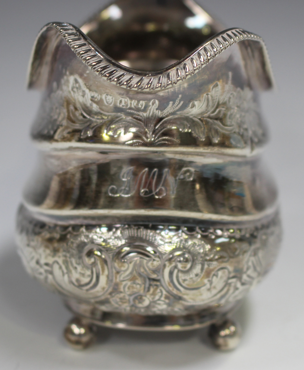 A George III silver cream jug of cushion form with gadrooned rim above a band of foliate scrolls, - Image 3 of 3