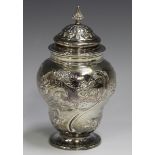 A Victorian silver tea caddy of ogee baluster form with domed cover, decorated in relief with