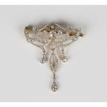 A gold backed and platinum fronted diamond brooch, circa 1910, in an Art Nouveau scroll pierced