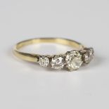 An 18ct gold ring, claw set with a row of five graduated cushion cut diamonds, Birmingham 1986,