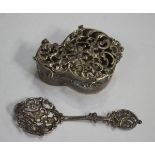 An Edwardian silver potpourri box and cover, the hinged lid cast and pierced with a pair of cupids