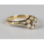 A gold, diamond and half-pearl cluster ring, mounted with a cushion cut diamond within a surround of