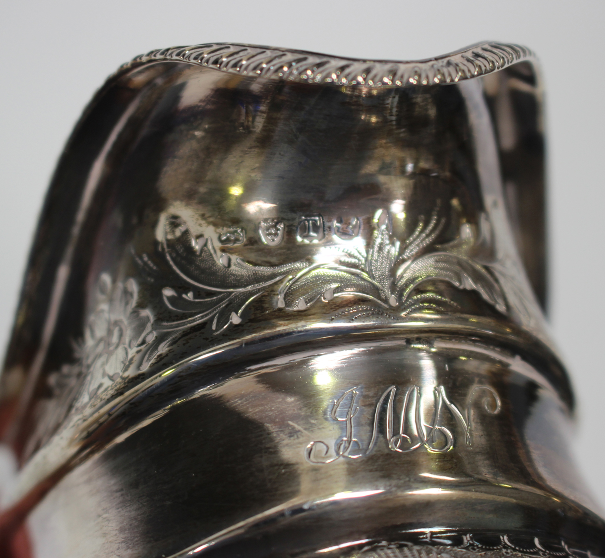 A George III silver cream jug of cushion form with gadrooned rim above a band of foliate scrolls, - Image 2 of 3