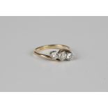 A gold, platinum and diamond three stone ring, claw set with a row of cushion cut diamonds in a