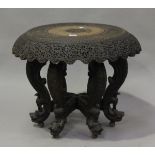 A late 19th/early 20th century Burmese hardwood revolving occasional table, profusely carved with