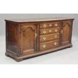 A George III oak dresser base, fitted with four drawers, flanked by arched panel doors, height 80cm,