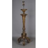 An impressive Baroque Revival giltwood triform torchère lamp standard, decorated with tassels and