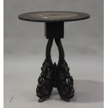 A late 19th century Burmese rosewood circular wine table, the top carved with foliage, the base with