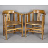 A pair of Edwardian Arts and Crafts oak tub back elbow chairs, attributed to Shapland & Petter,