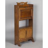 An Edwardian Arts and Crafts oak student's bureau, in the manner of Liberty & Co, the fall flap