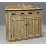 A late 19th/early 20th century pine side cabinet with a shaped gallery back above drawers and