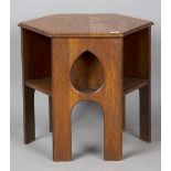 An early 20th century Arts and Crafts oak hexagonal book table, three sides pierced with teardrop